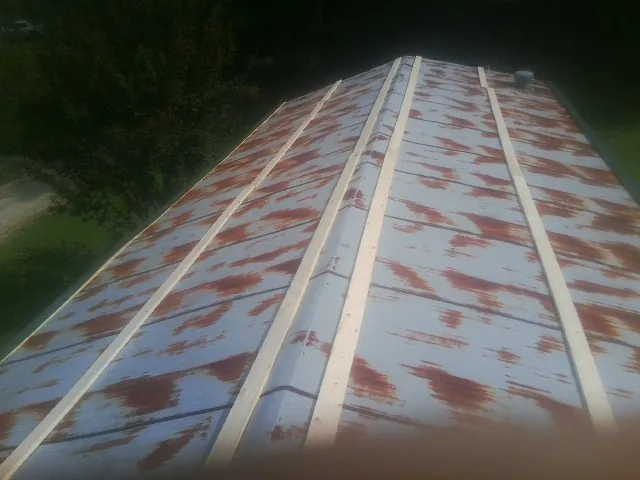 Rusted metal roof panels with new wood purlins before replacement — Storm Damage Roof Repair in Pine Ridge by Roofing Brothers